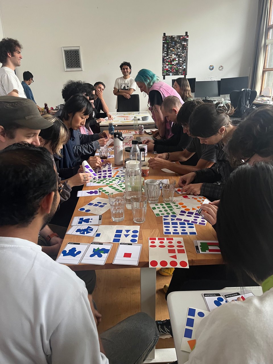 A group of people around a table working with stickers and crayons