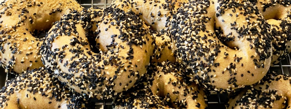 Several everything bagels on a cooling rack