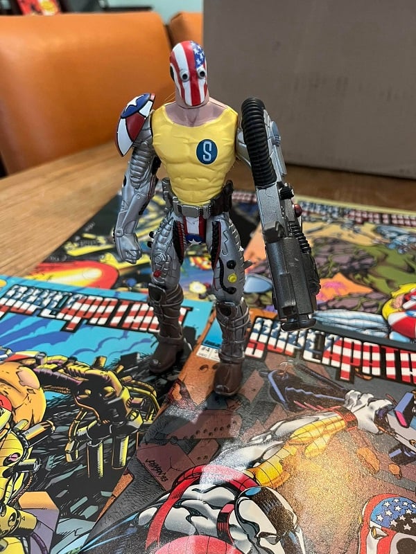 A SuperPatriot action figure, standing on top of the four issues of the first SuperPatriot mini-series.