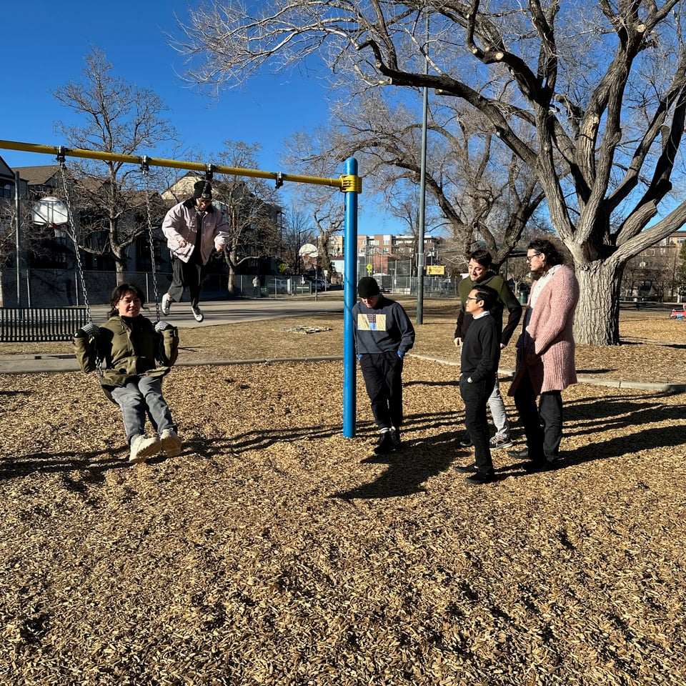 Michelle Azzi, Unofficial Director of Play for The Company, leads a group in swinging (the wholesome kind) on swing sets..