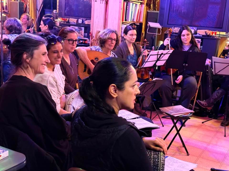 A group of people seen from the side, smiling and holding instruments