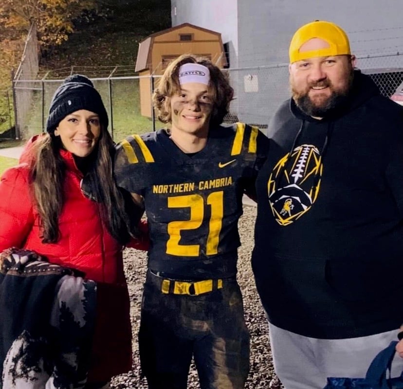 Maverick Baker with his mom and dad after a football game.
