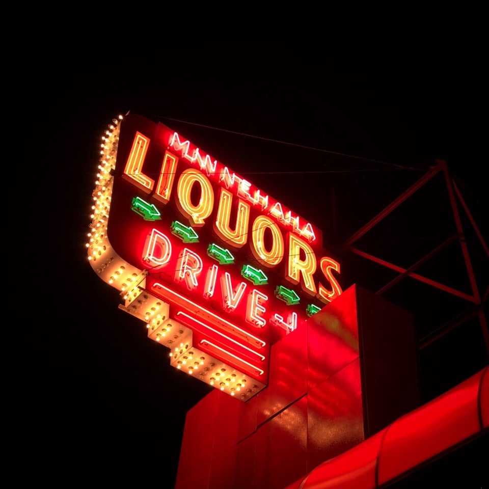 Neon sign that says "Minnehaha Liquors Drive-In"