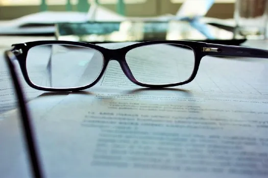 a pair of glasses laying on top of a document