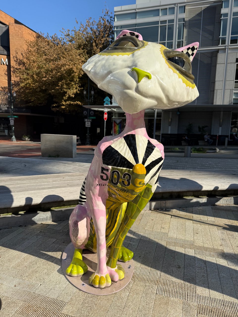 A stylized cat sculpture is painted in colorful patterns