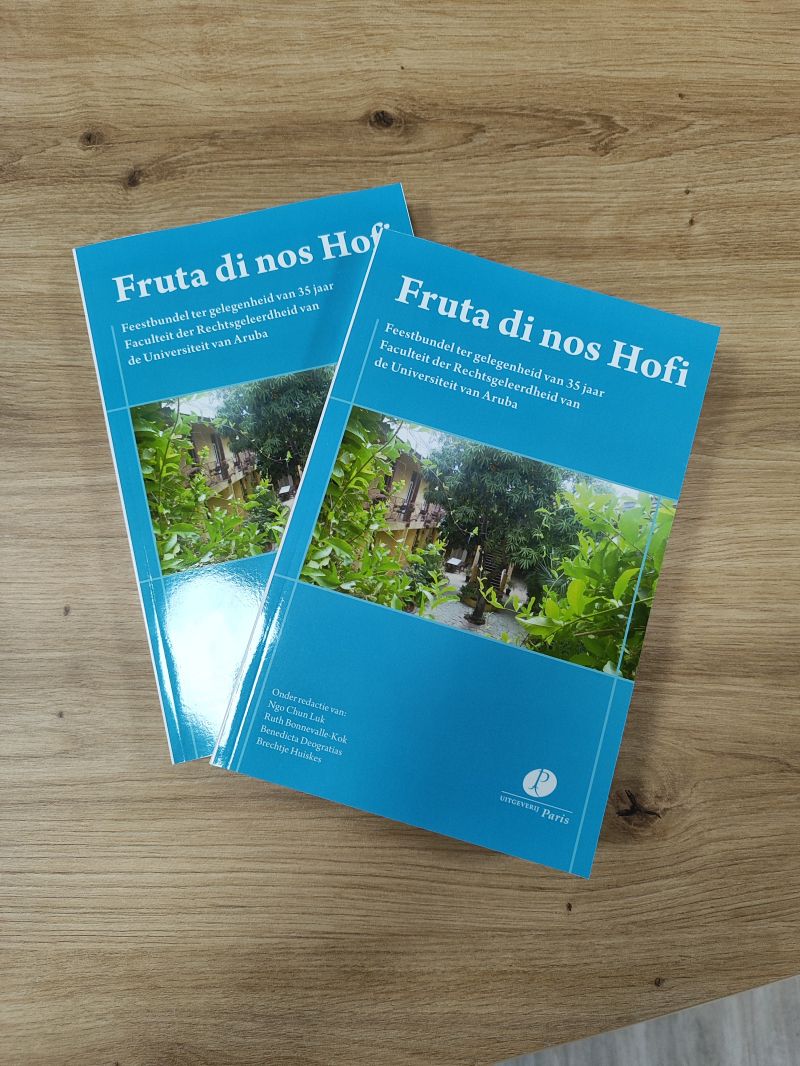 Physical copies of the Fruta di nos Hofi book, with a blue cover and a picture of one of the University's gardens.