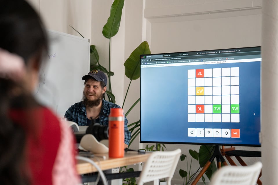 Alex showing a scrabble-like game on screen.