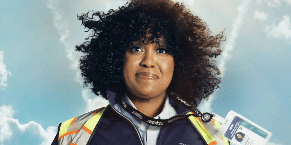 Natasha Rothwell dressed as an airport employee against a blue sky.