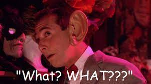 Pee Wee Herman in a suit with a large ear saying 'What? WHAT??'
