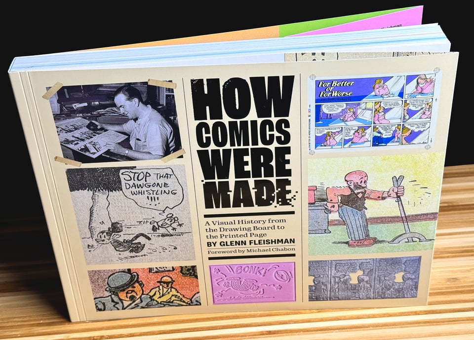 How Comics Were Made book at an angle on a bamboo table to show the cover and thickness
