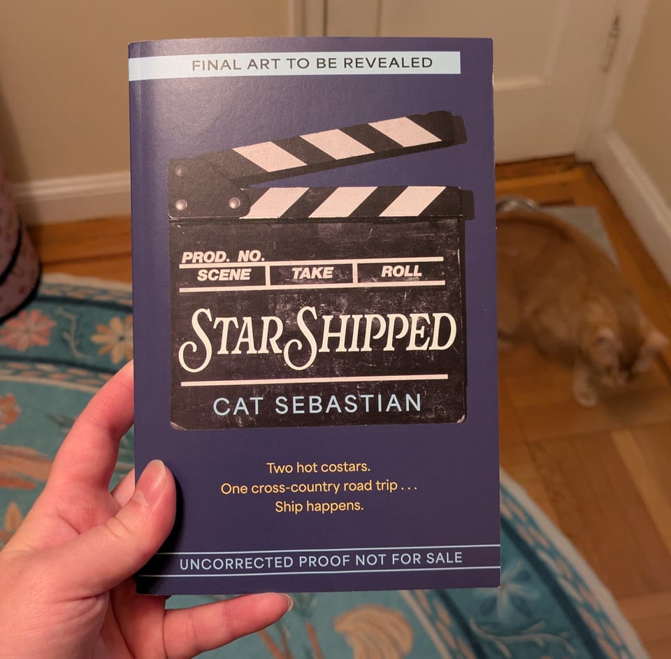 My hand holding up the arc. The cover art is not final and shows an illustrated movie clapper.