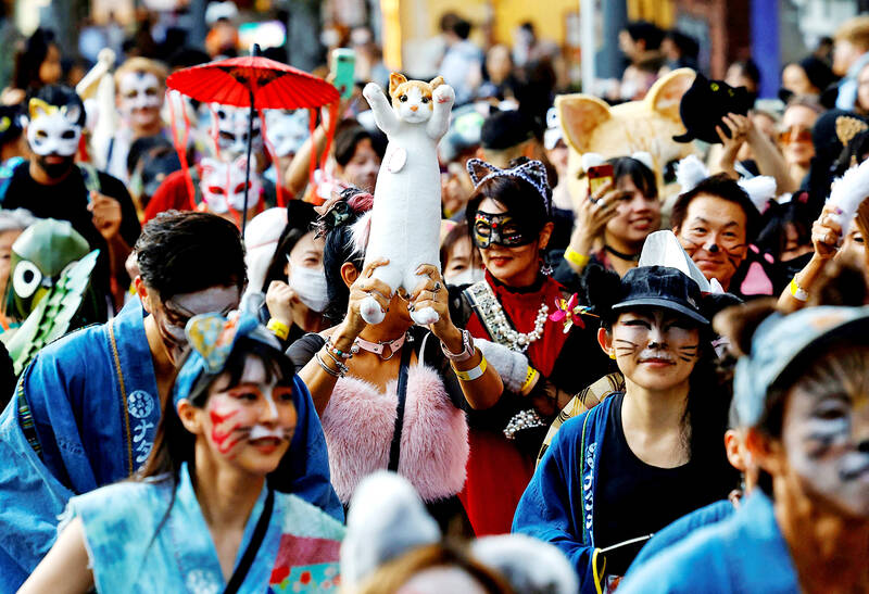 A busy parade with people in cat makeup and masks