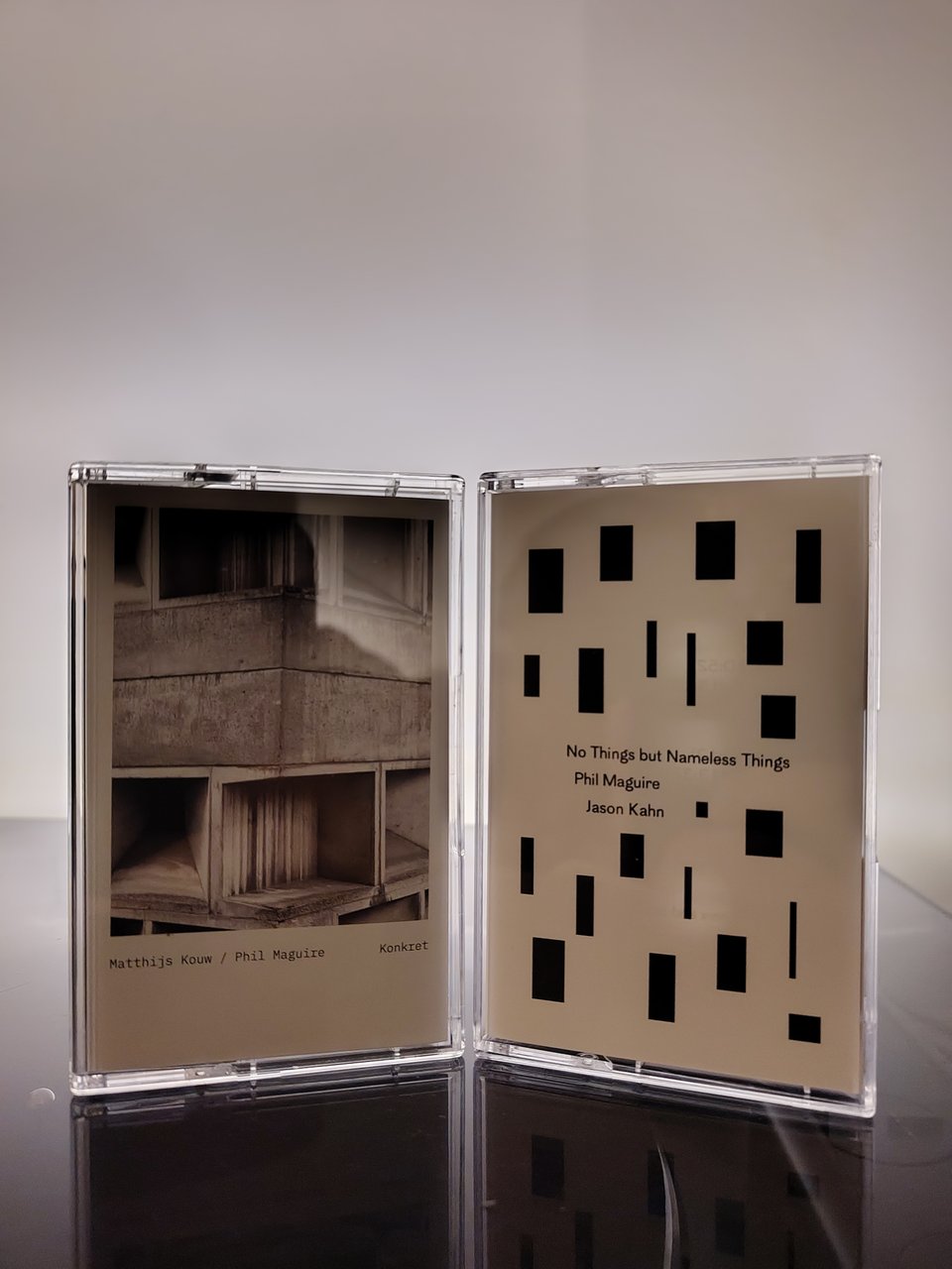Two cassette tapes stood next to each other in front of a white background.