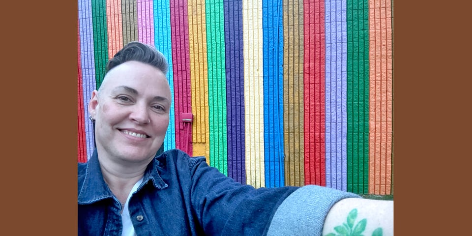 Leoh in front of painted stripes on a building
