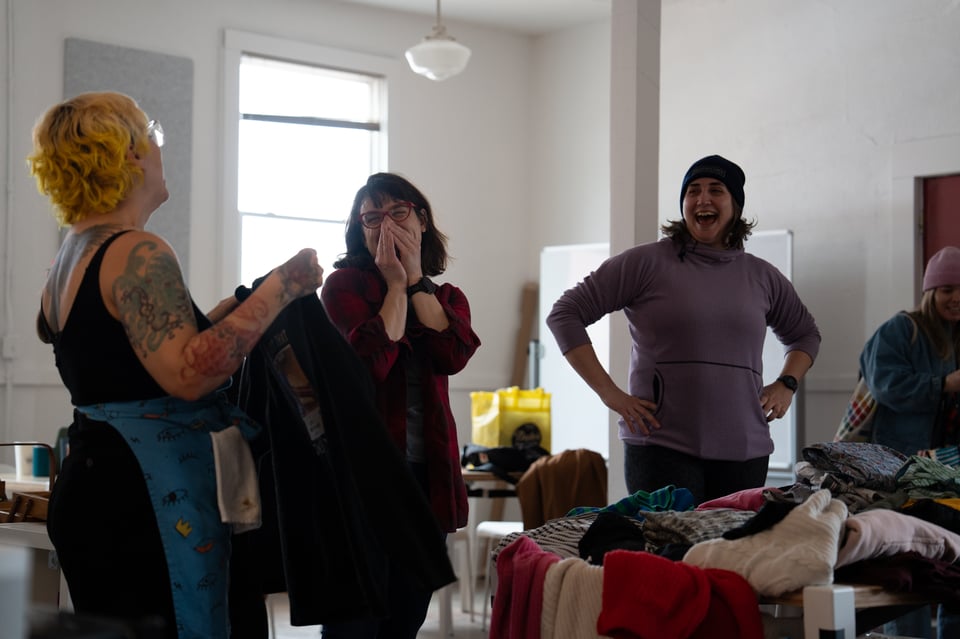 Women laughing at a sweater.