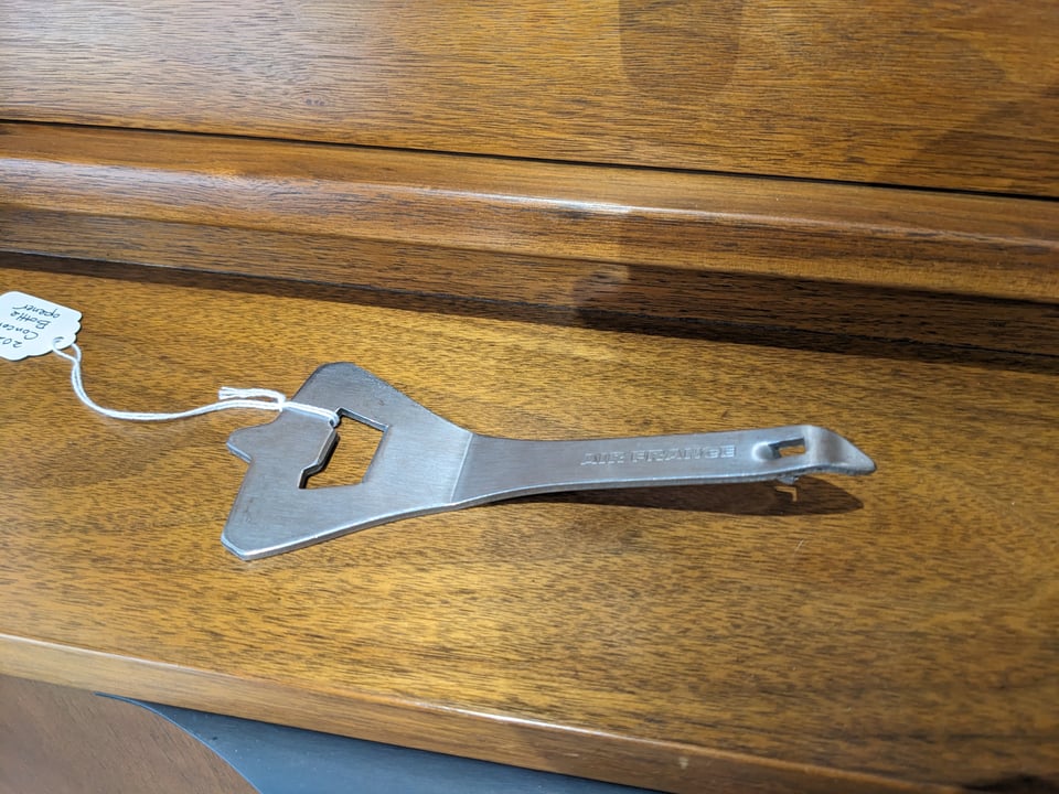 a metal bottle and "churchkey" can opener in the shape of the Concorde supersonic jet.