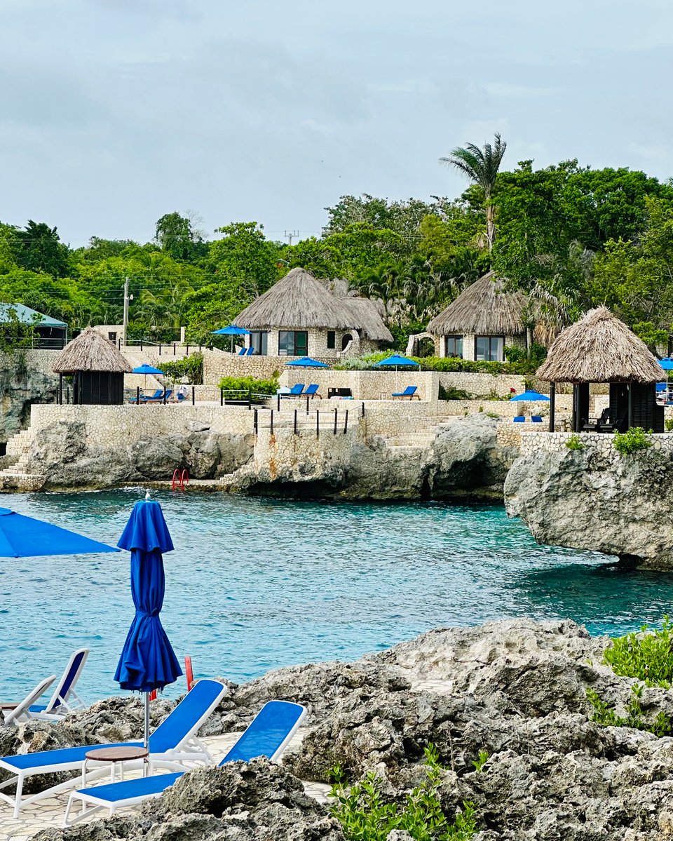 a beach with lounge chairs and umbrellas