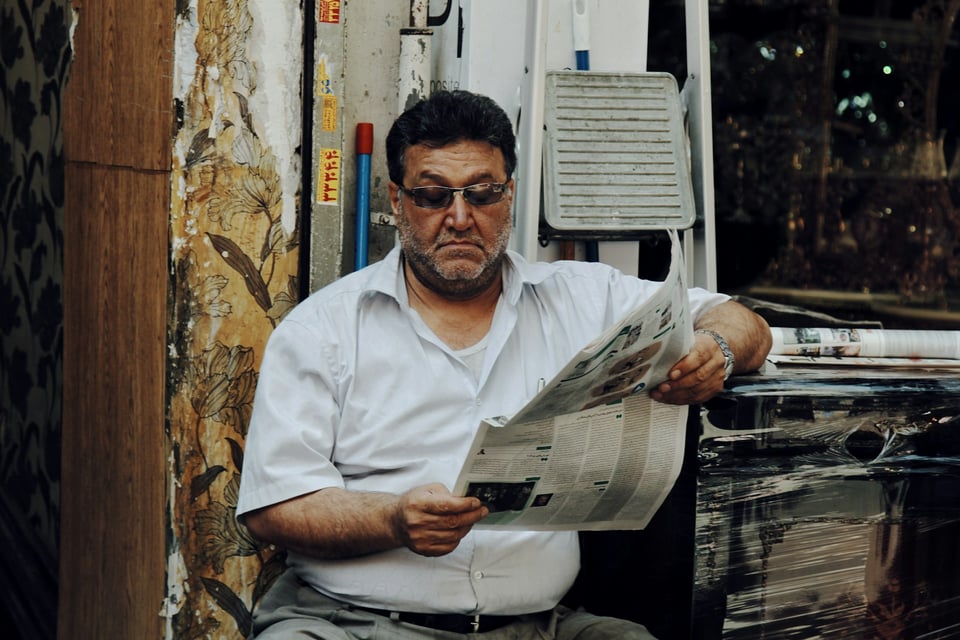 Stacks of newspapers neatly laid out on a table. Photo by Cici Hung on Unsplash.