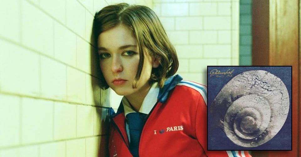 Snail Mail wearing a sport jacket. In a corner there is the cover of her album Ricochet.