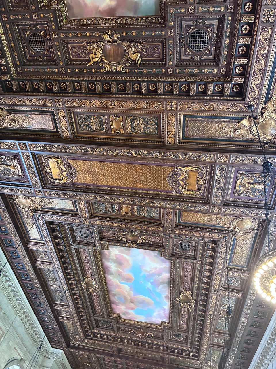 an old ceiling with intricately carved gold and a painted sky