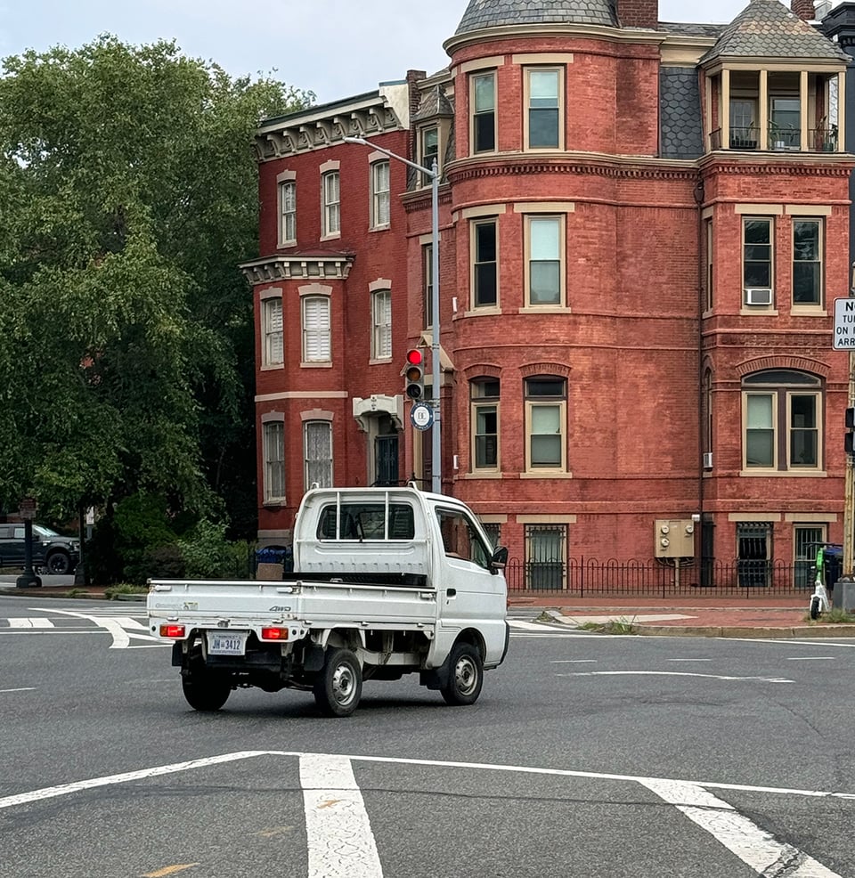 A tiny pickup truck on a street.