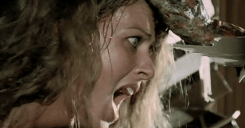 From Lucio Fulci's 1979 film Zombie, a terrified young woman is being pulled by her hair towards a long sharp wooden splinter, aimed directly at her right eye