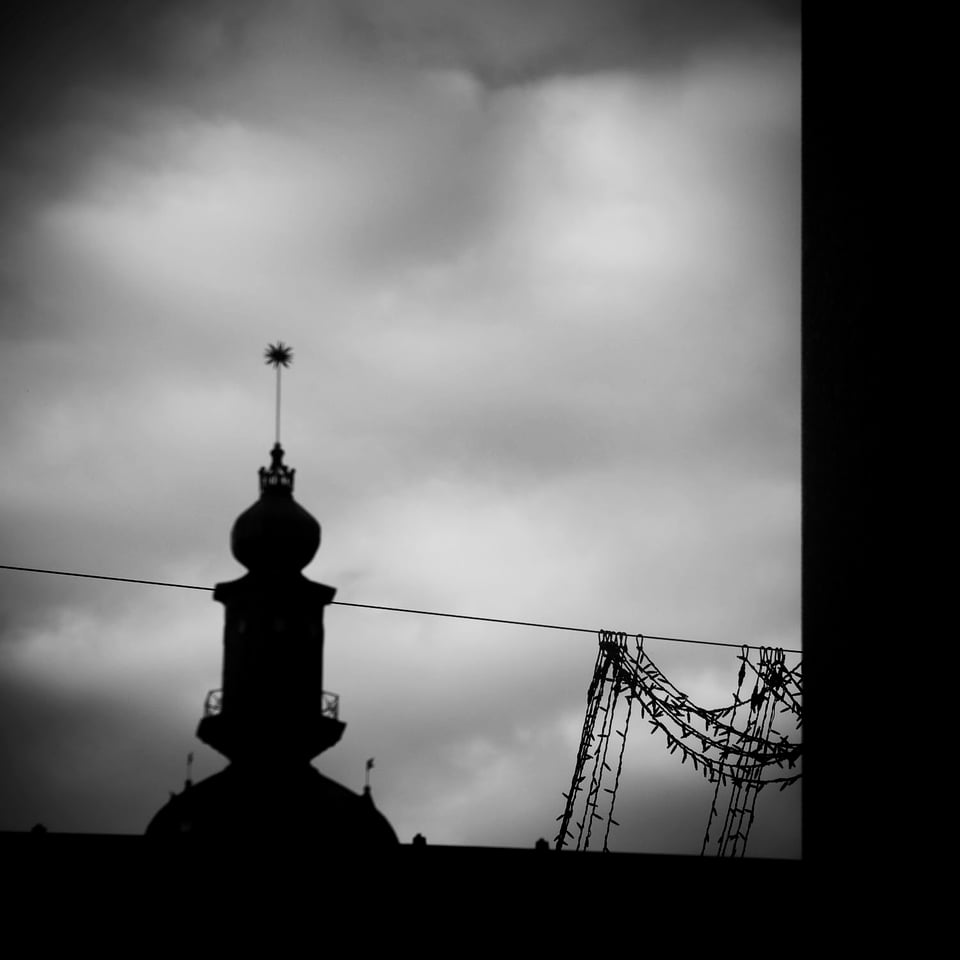 Silhouette of tower against cloudy, dark, dramatic sky.