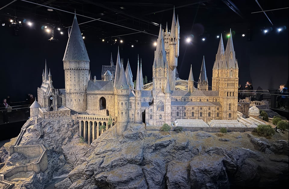 A large model mockup of Hogwarts castle in the middle of a room that people can walk around on two levels to see different angles and all the details.