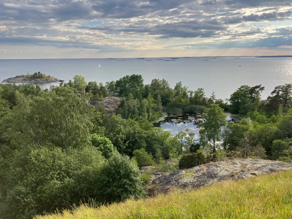 the island Vallisaari, looking over trees and a lake and the ocean