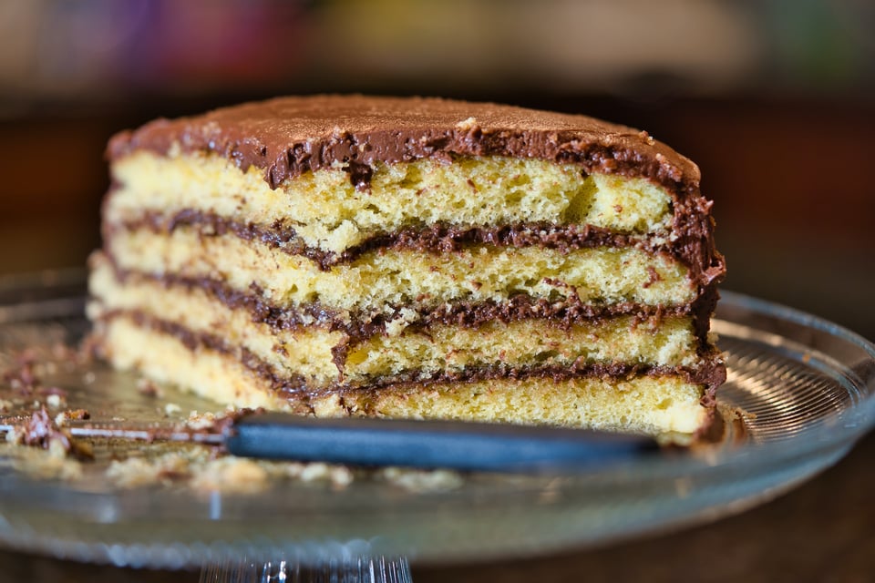 Description: a close-up, cutaway view of a layered chocolate cake. Photo by Clint Patterson on Unsplash.
