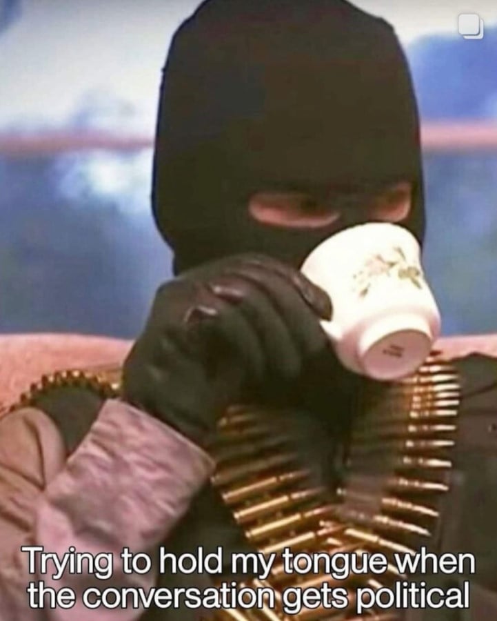 A man wearing a balaclava, black gloves, and twin ammo bandoliers, sipping from a tea up. Text reads: Trying to hold my tongue when the conversation gets political.