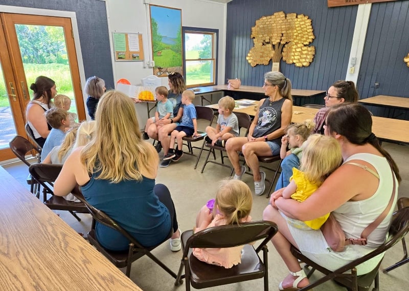 Eleven kids, accompanied by five of their grownups, listened raptly as FSPA member Linda Lilja, a retired teacher and FSPA member, read Eric Carle’s classic “The Very Hungry Caterpillar” at our July 9 Nature Explorers class. / Photo by Pamela Miller