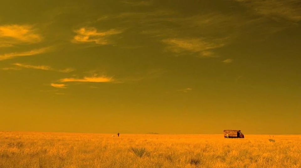 A screengrab of a scene of a field in Mexico as depicted in Breaking Bad, with a heavy yellow filter.