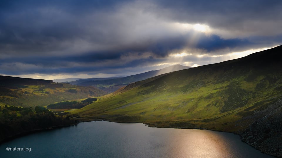 Overview of a lake from the top, while light illuminates it