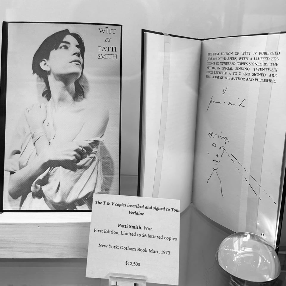 Photo of the book WITT by Patti Smith, on a shelf at an antiquarian book fair, with a card about its provenance and price ($12,500)