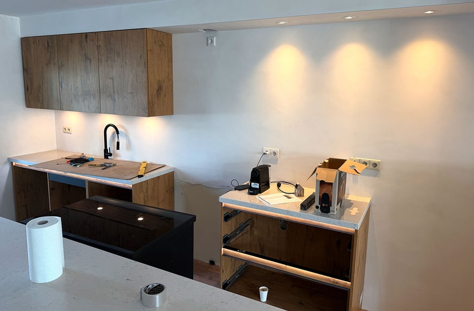 Kitchen cabinets and countertops begin to be installed.
