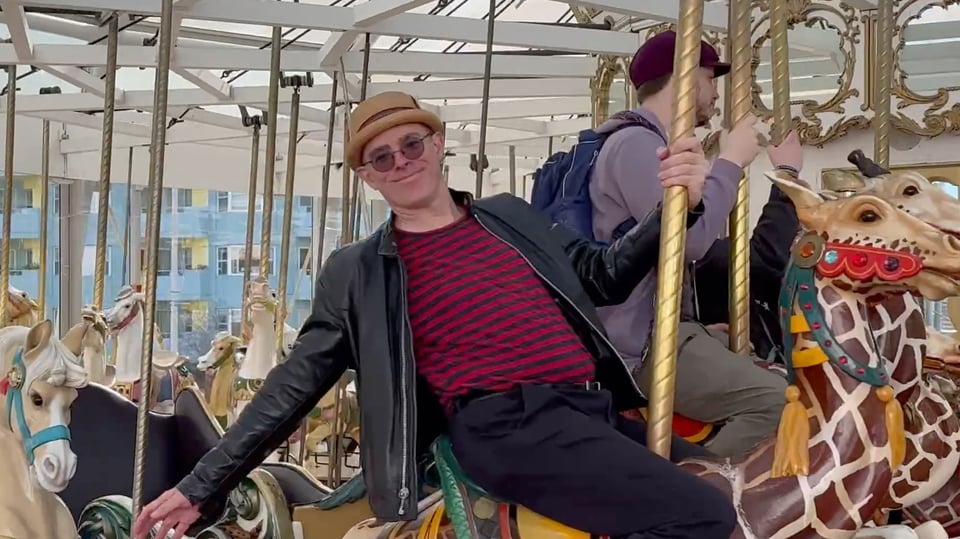 Ryan riding a giraffe on the carousel.