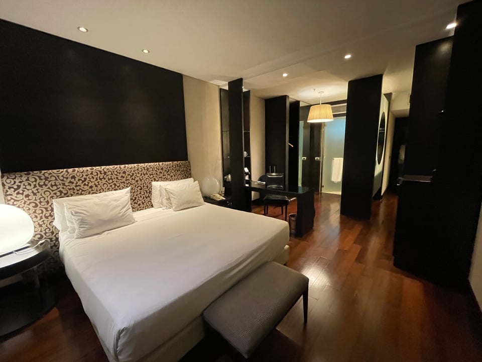 Hotel room with a large double bed, desk and bathroom.