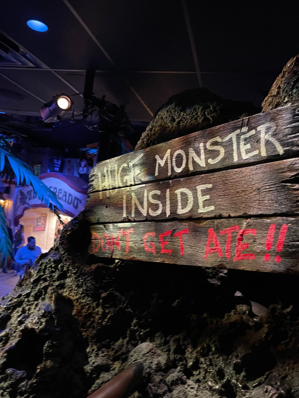 The entrance to a kind of haunted cavern deal made of craggy foam rock. There’s a sign that reads “HUGE MONSTER INSIDE: DON’T GET ATE!!”