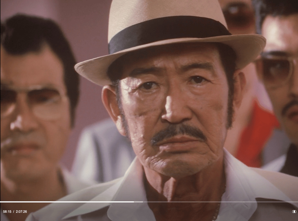 screen shot of yakuza angrily staring at bureaucrat