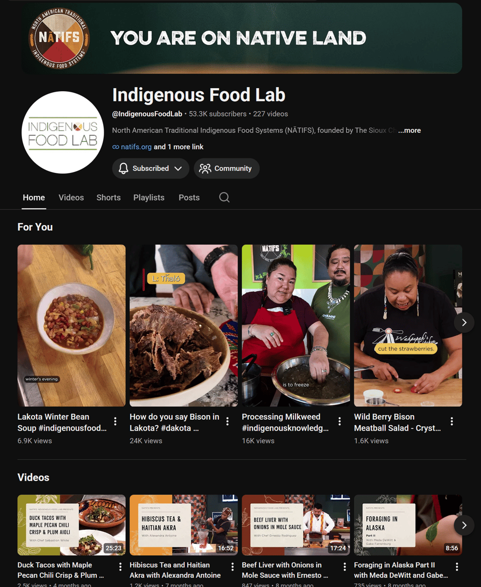A screenshot from the Indigenous Food Lab's YouTube Channel, featuring YouTube shorts on Lakota winter bean soup and how to say Bison in Lakota, along with longer-form videos like duck tacos with maple pecan chili crisp, and hibiscus tea and Haitian Akra.