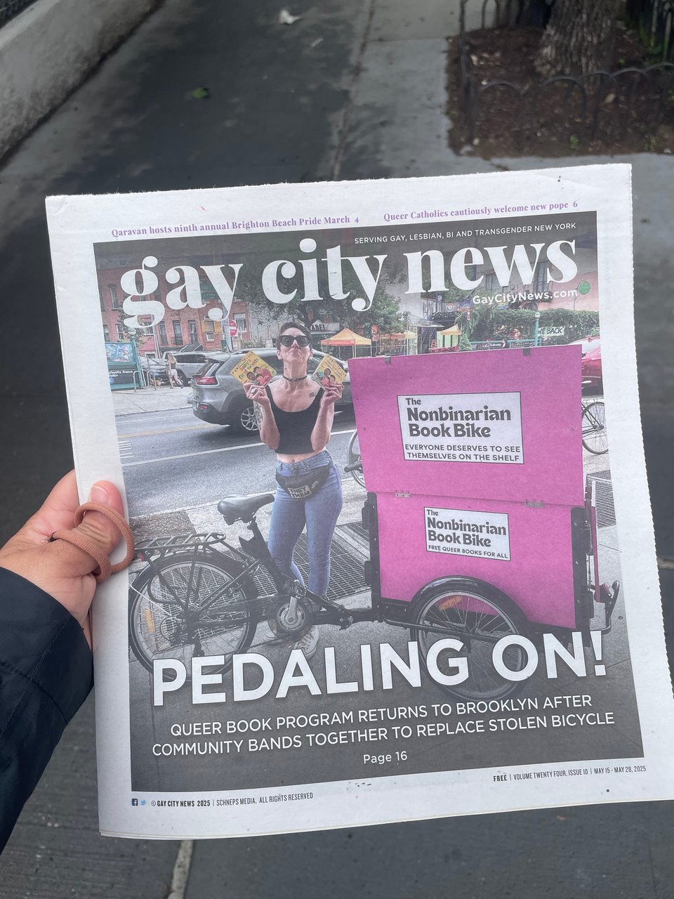 A print copy of Gay City News with founder Kay with the Nonbinarian Book Bike