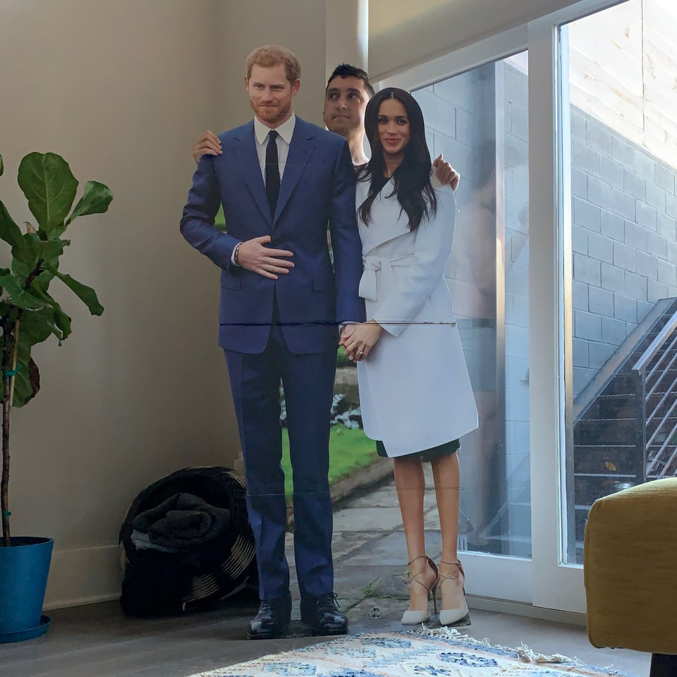 The author standing behind a cardboard cutout of the Duke and Duchess of Sussex.