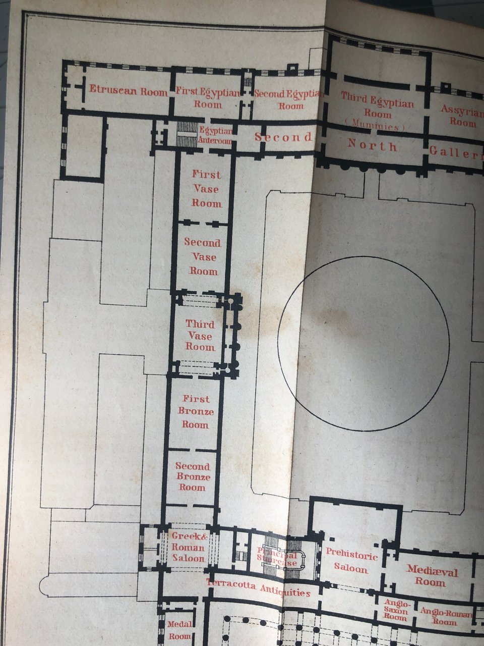 a fold-out map of the British Museum as it was in 1889, with rooms labeled in red on a black line floor plan: First Vase Room, Second Vase Room, Third Vase Room, First Bronze Room, etc. Also of interest: "Greek & Roman Saloon," "Prehistoric Saloon."