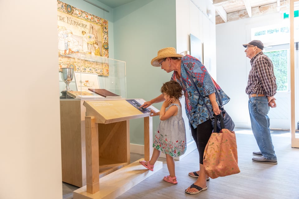 Two adults and a childe read interpretive panels and look at displays.