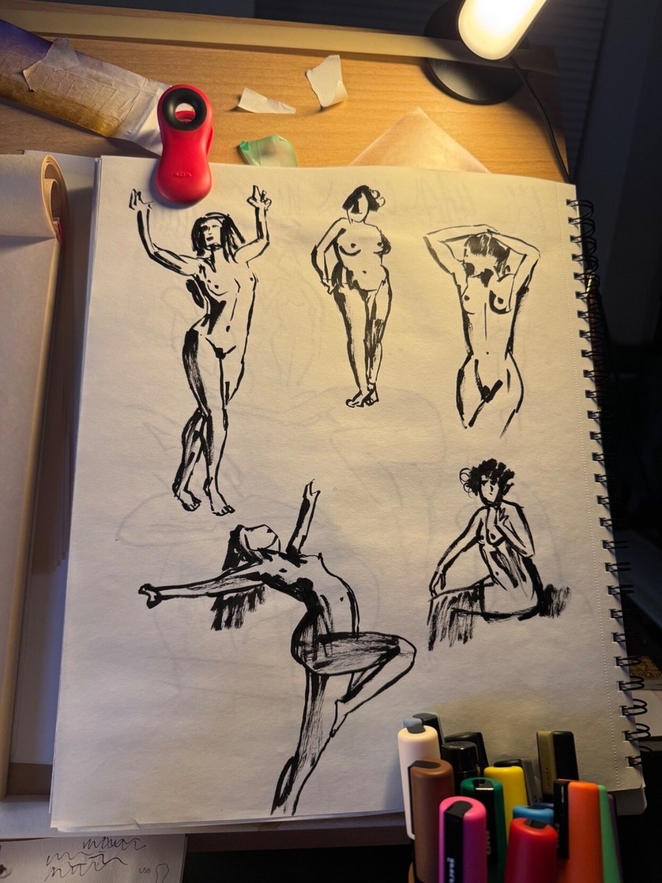 photo of my easel with a sketchbook filled with 5 black ink nude female figures i sketched