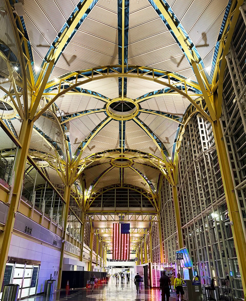 An airport terminal with an American flag.