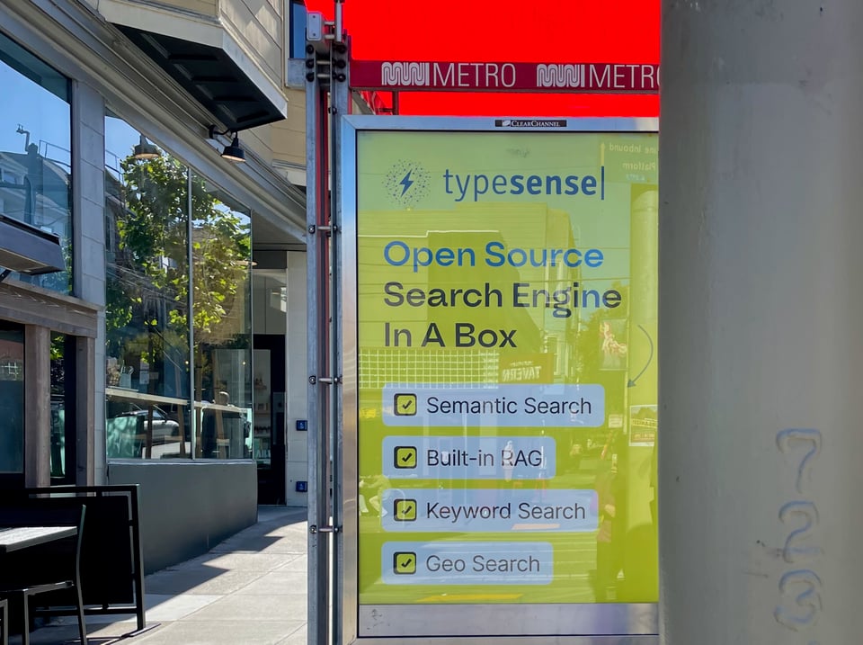 an ad for Typesense on a Muni stop reads, "Open Source Search Engine In A Box: Semantic Search, Built-in RAG, Keyword Search, Geo Search."