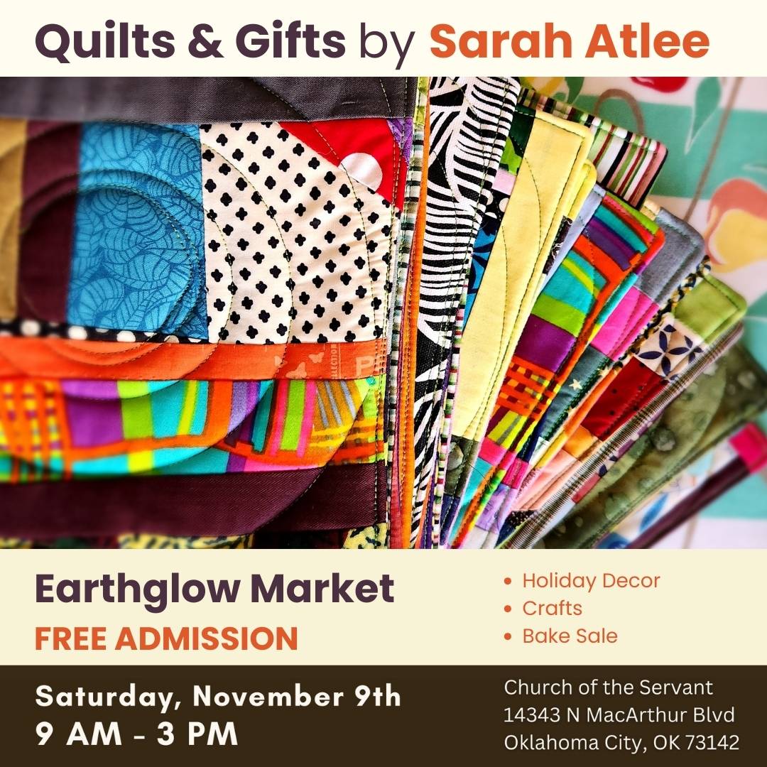 A colorful stack of patchwork potholders sitting on a vintage tablecloth.